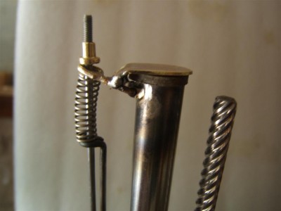 le ressort sert à plaquer le joint ; la vis règle le tarage du ressort en fonction du servo